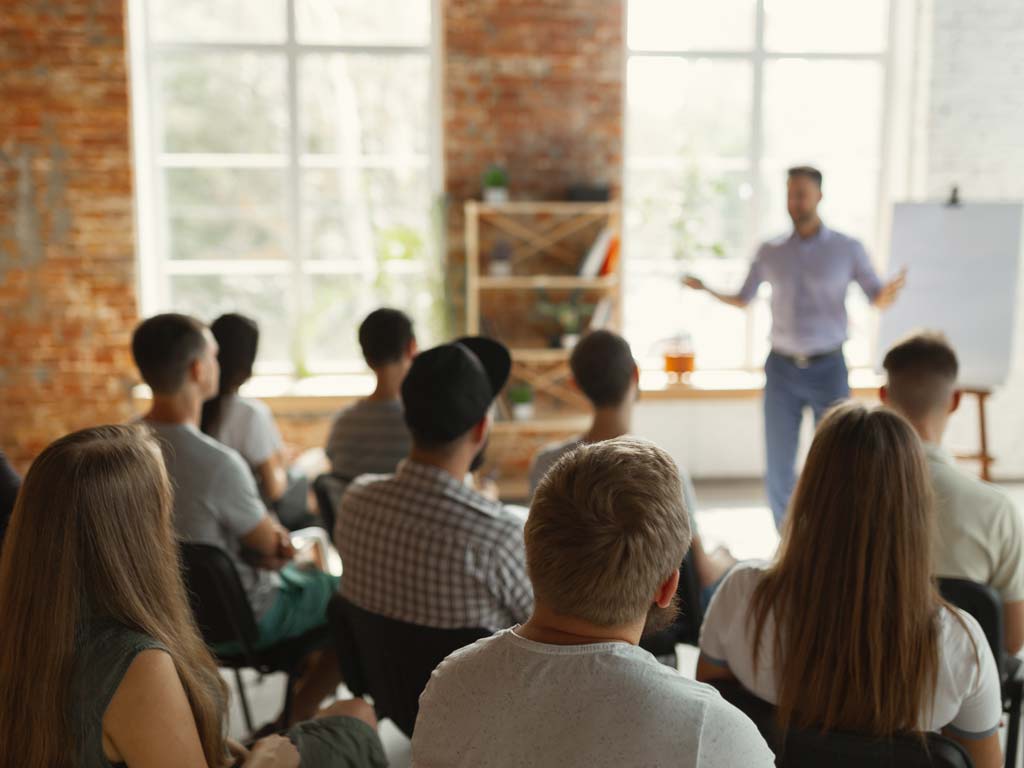 A large group of coaching students listening to a seminar